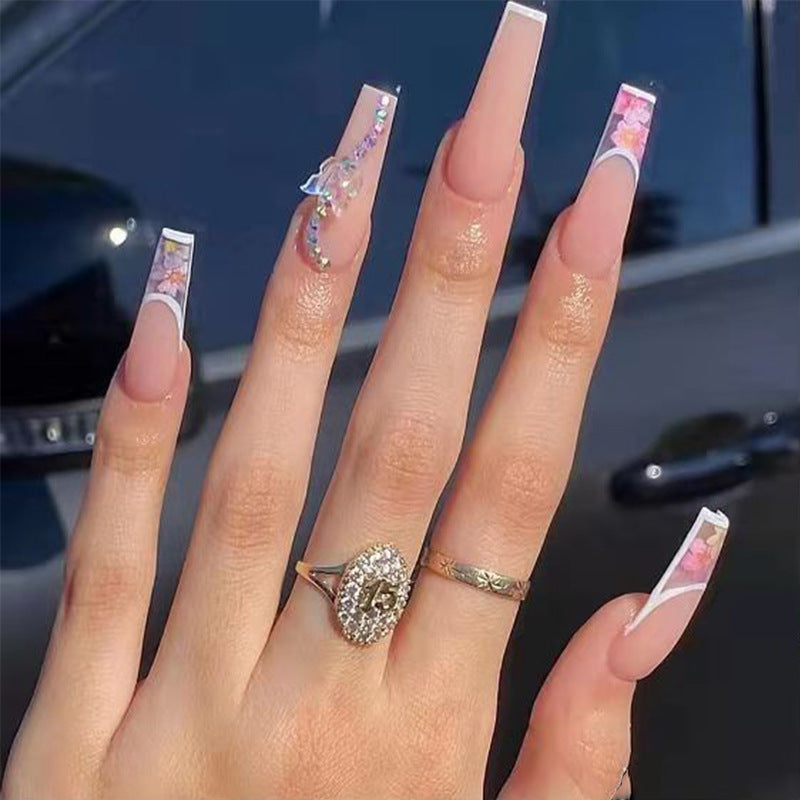 Kunstnagelspitzen im eleganten französischen Design mit floralem Akzent Karnz