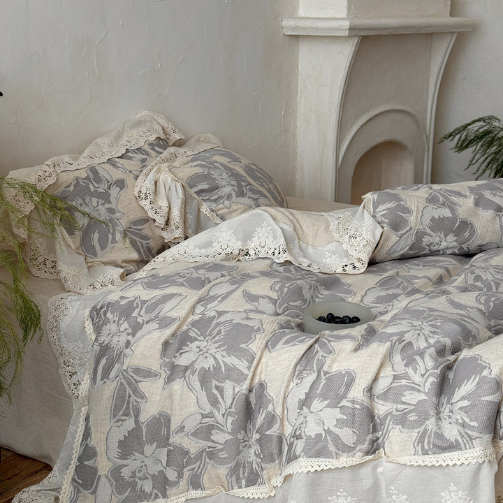 Leicht gesteppte Baumwoll-Bettwäschegarnitur im Landhausstil mit Spitzenvolant und großem Blumenmotiv