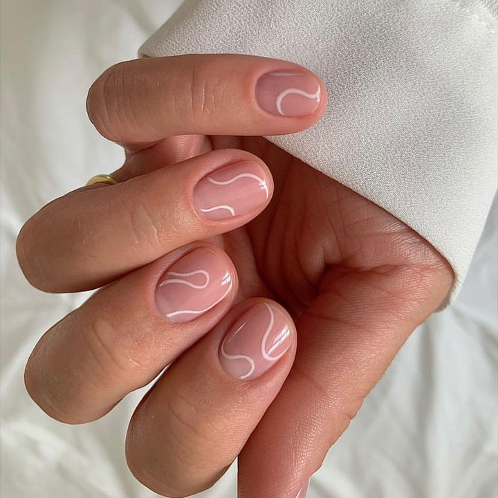 Elegantes Press-On-Nageldesign mit kunstvollem weißen Wirbel Karnz