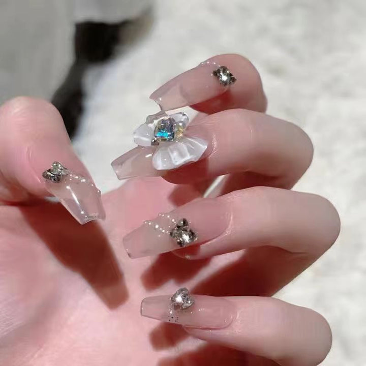 Kunstvolle Nagelkunst mit Glitzer- und Blumenapplikationen Karnz