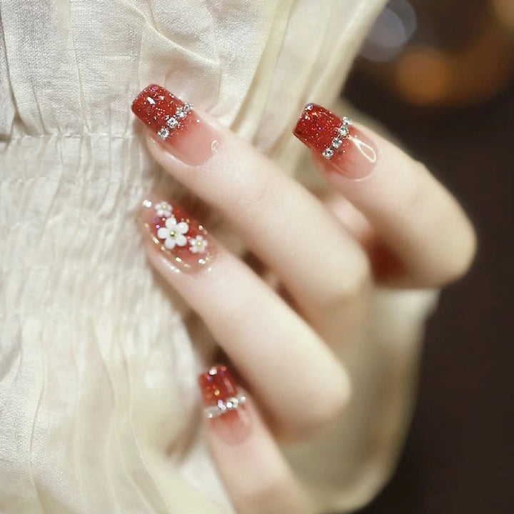 Künstlerische Press-On Nagelkunst mit floralen und Glitzerakzenten Karnz