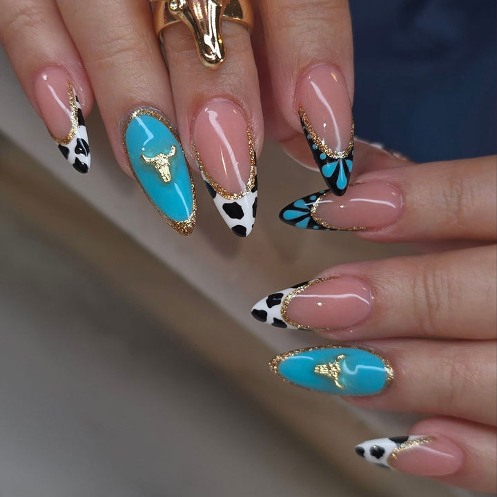 Künstlerische Stiletto-Nagelverlängerungen mit Kuhmotiv und goldenen Akzenten Karnz