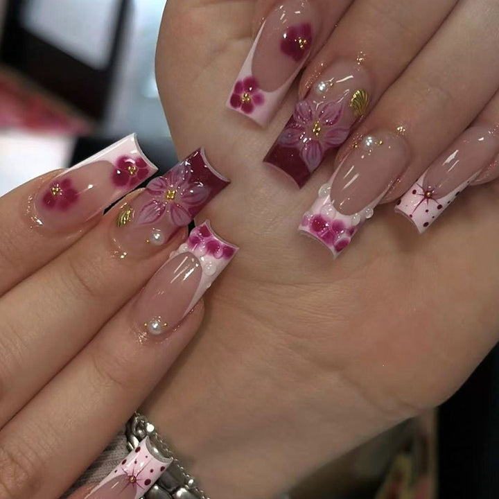 Kunstnagelset mit floralen 3D-Details und Glitzerakzenten Karnz