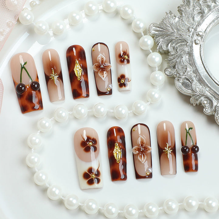 Elegantes Nagelkunstset mit floralen und goldenen Akzenten Karnz