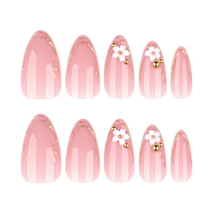 Kunstvolle Nagelgestaltung mit goldenen Akzenten und floralen Details Karnz