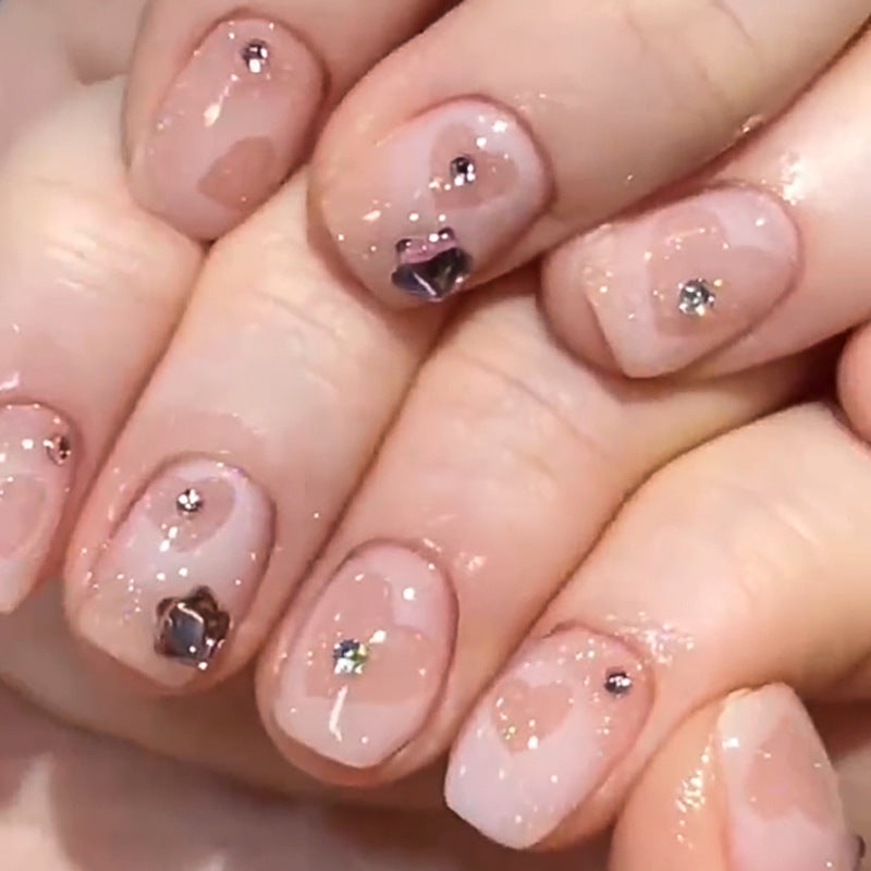 Kunstvolle Nagelkunst mit Glitzer- und Herzmotiven Karnz