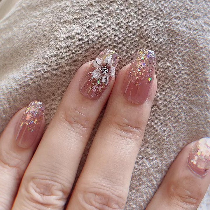 Künstliche Nagelverlängerungen mit floralem Design und Glitzerakzenten Karnz