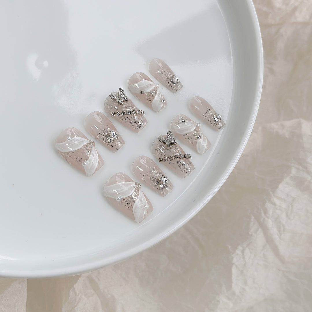 Elegantes dekoratives Press-On-Nagelkunstset mit silbernen Schmetterlingen und Edelsteindetails