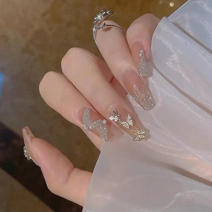 Glamouröse Nagelkunst mit Strass- und Schmetterlingselementen Karnz