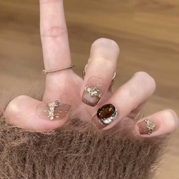 Künstliche Nagelkunst mit Glitzer- und Schmuckverzierungen Karnz