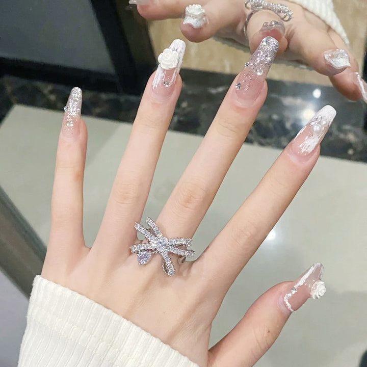 Kunstnagelset mit eleganten 3D-Blüten- und Glitzerverzierungen Karnz