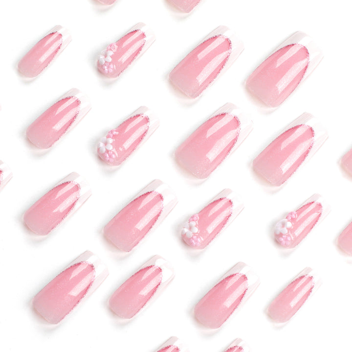 Kunstvolle Nagelverlängerungen mit Glitzer- und Blumenakzenten Karnz