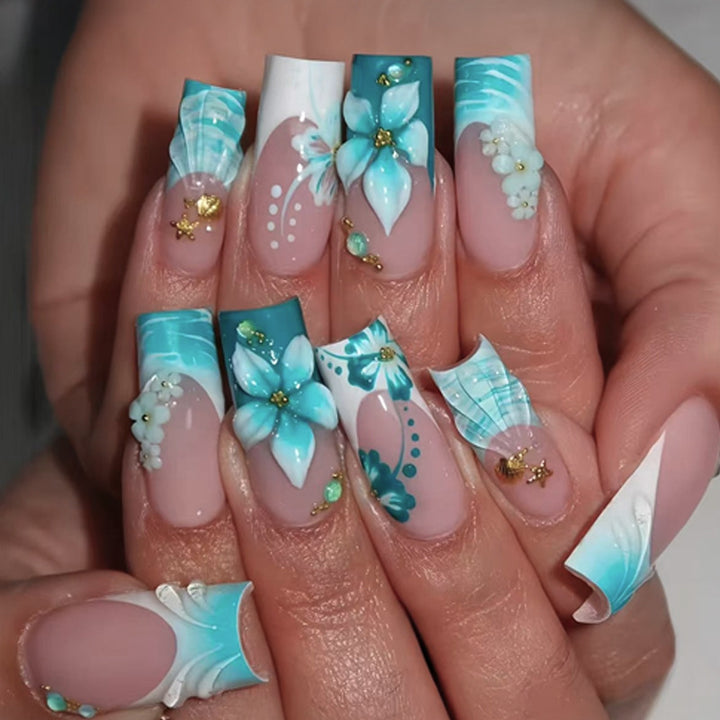 Kunstnagelset mit eleganten blumigen Verzierungen und Glitzerakzenten Karnz