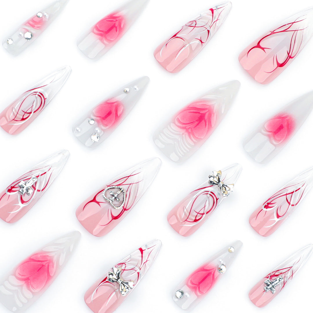 Kunstvolle Stiletto-Nägel mit eleganter floralem Akzent und Glitzerverzierungen Karnz