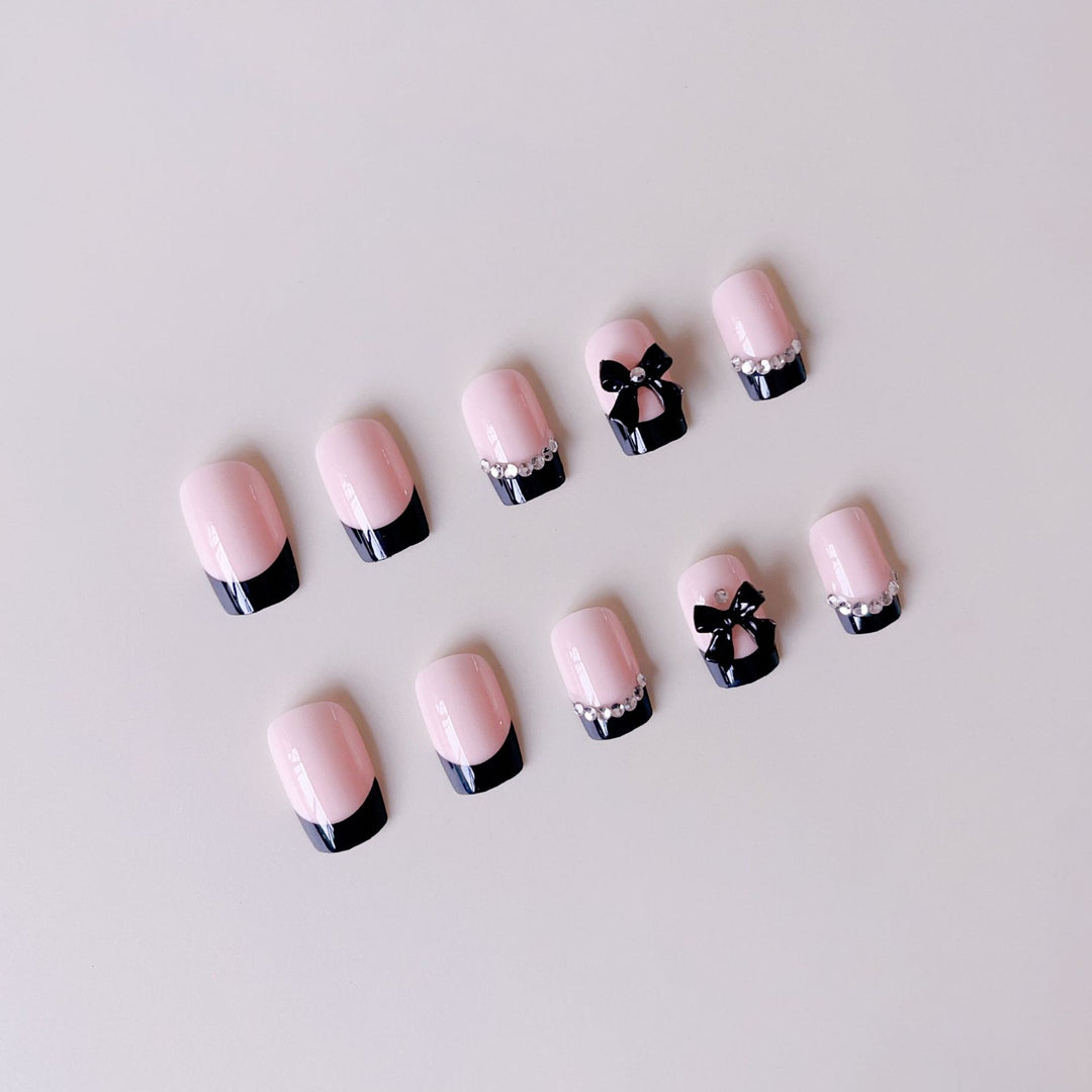 Kunstnagelset mit eleganten Schleifen und Glitzerverzierungen Karnz
