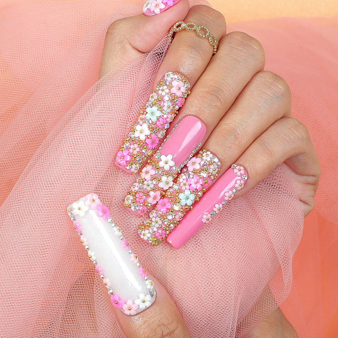 Kunstnagelset mit floralen Verzierungen und Glitzerakzenten Karnz