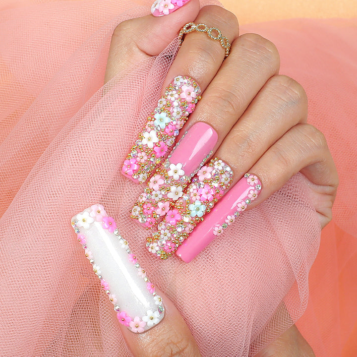 Kunstnagelset mit floralen Verzierungen und Glitzerakzenten Karnz