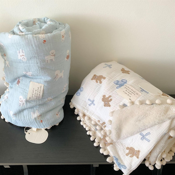 Kinderwende-Kuscheldecke aus Baumwoll-Musselin mit Pompon-Bordüre