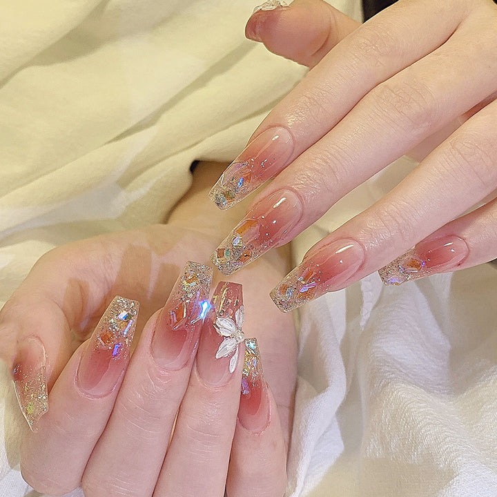 Kunstnagelset mit floralen und glitzernden Akzenten Karnz