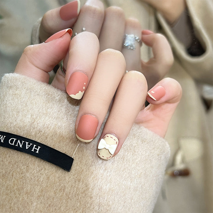 Kunstvolle Nagelnägel mit dekorativen Bogenmotiven und French-Spitzen Karnz