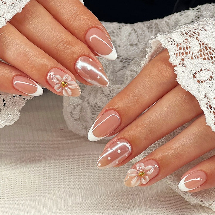 Kunstnagelset mit eleganten französischen Spitzen und zarten Blütenakzenten Karnz