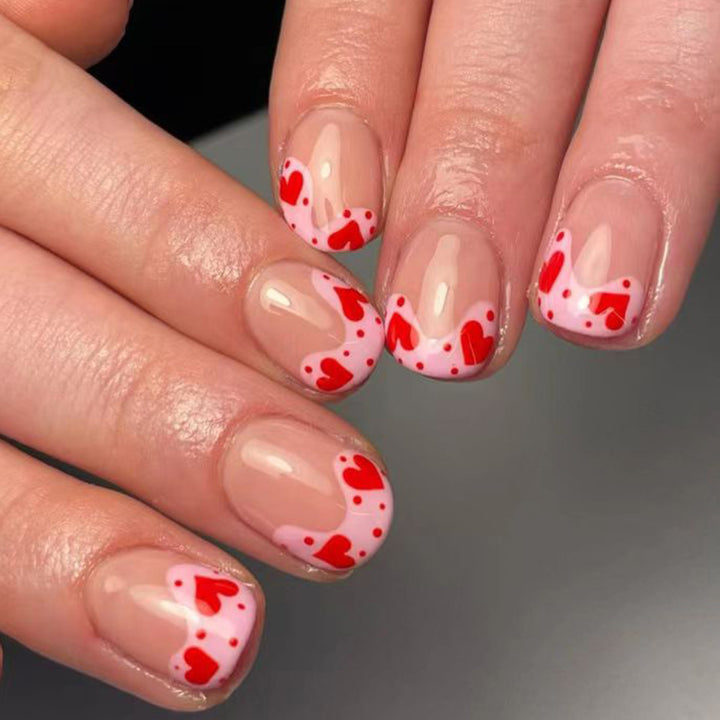 Kunstvoll gestaltete Nagelspitzen mit Herzmotiven Karnz