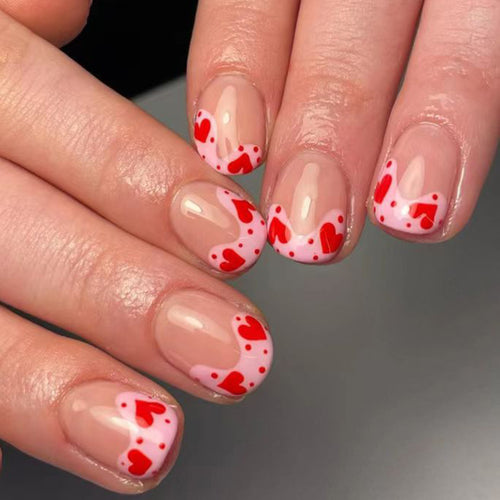 Kunstvoll gestaltete Nagelspitzen mit Herzmotiven Karnz