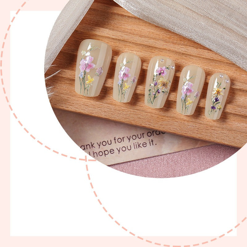 Kunstnagelset mit floralen Verzierungen und glamourösen Details Karnz