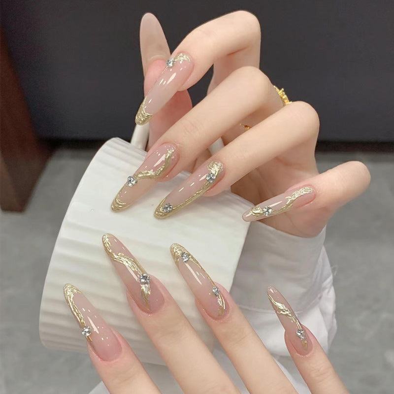 Kunstnagelset mit elegantem Gold-Design und funkelnden Applikationen Karnz