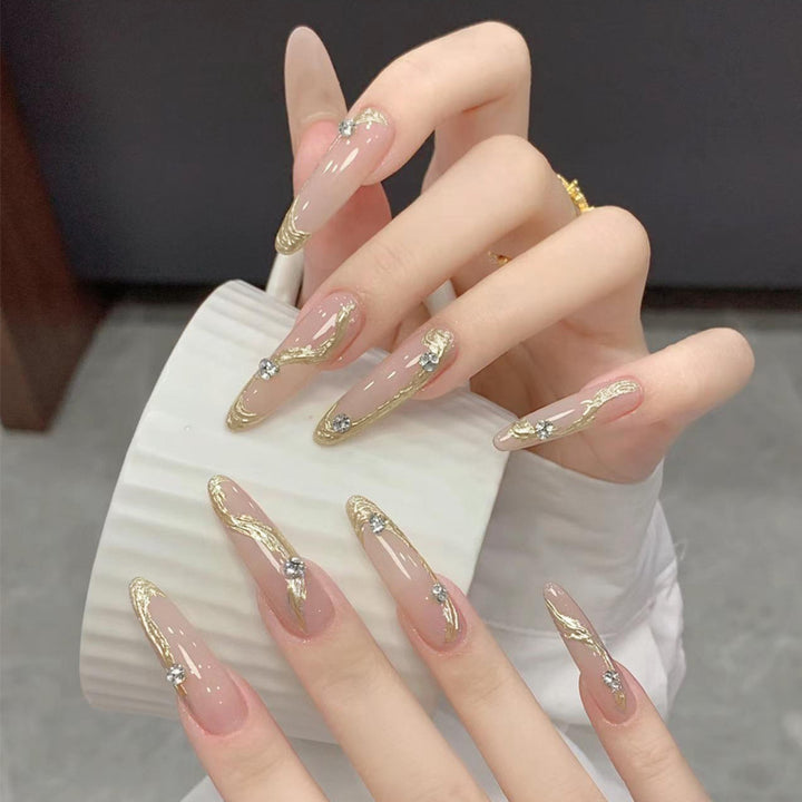 Kunstnagelset mit elegantem Gold-Design und funkelnden Applikationen Karnz