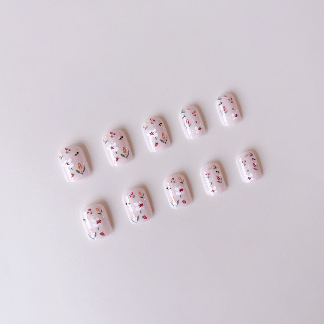 Kunstnagelset mit fröhlichen Blumen- und Bienendesigns Karnz