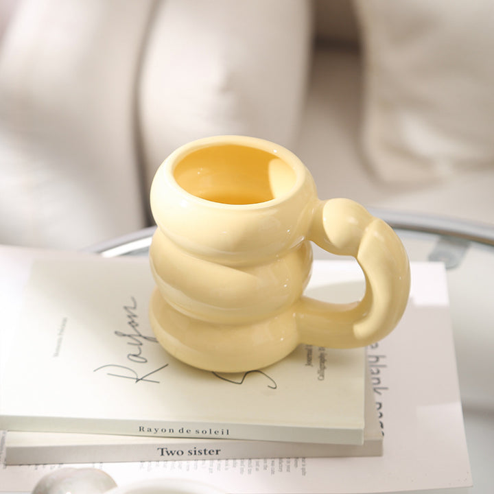 Skulpturaler Keramikbecher mit irisierender Glasur und gewölbtem Ringhenkel