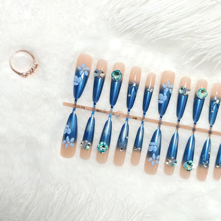 Elegante Kunstnägel mit floralen Applikationen und Glitzerelementen Karnz
