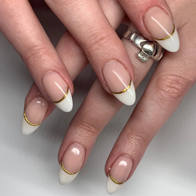 Kunstvolle French-Tip Nägel mit Goldakzenten Karnz