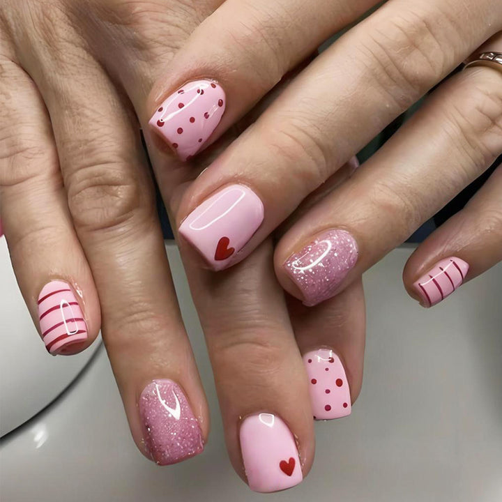 Kunstnagelset mit verspielten Herzen und Glitzerakzenten Karnz
