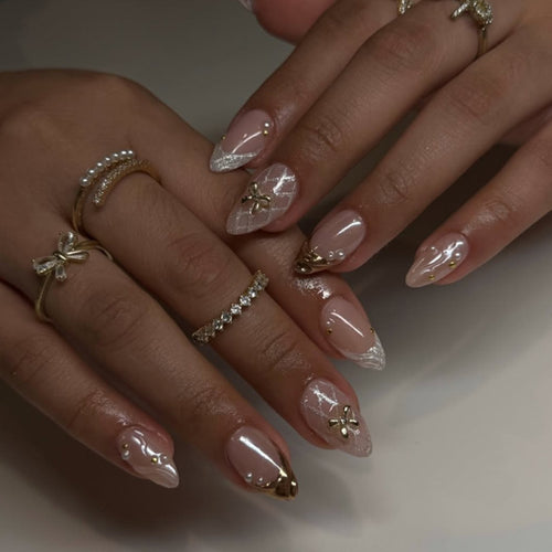 Kunstvolle Stiletto-Nägel mit Glitzer- und Blütenakzenten Karnz