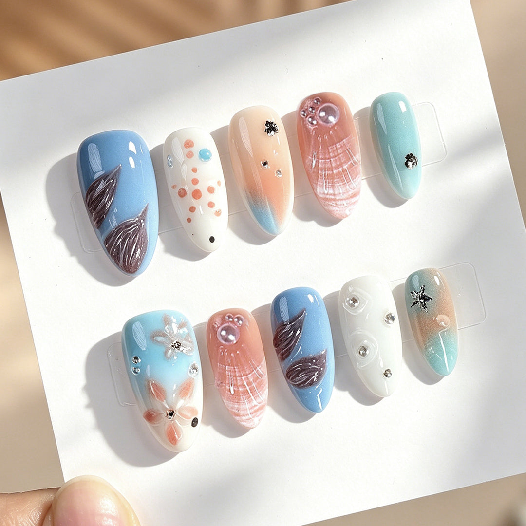 Kreatives Kunstnagelset mit zarten floralen und maritimen Designs Karnz