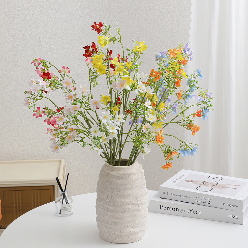 Künstlicher Blütenzweig mit zarten blauen Blumen und grünen Beeren Karnz