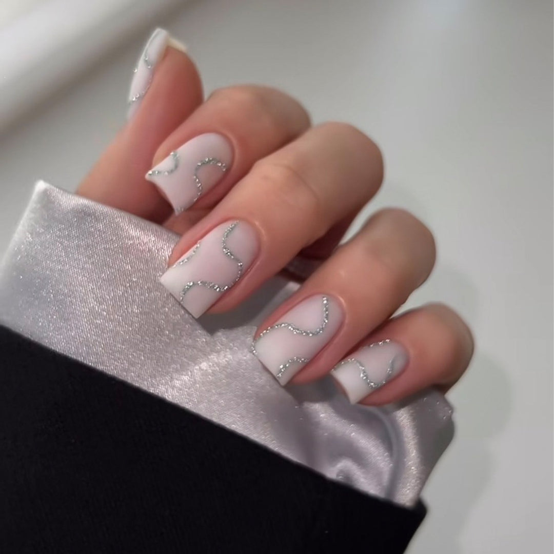 Künstliches Nagelset mit eleganten Linien und Glitzerakzenten Karnz