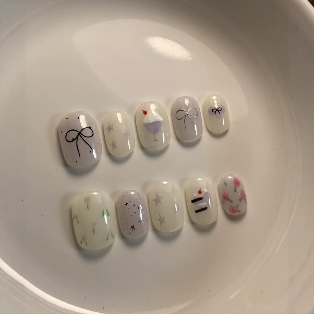 Künstlerisches Press-On Nagelkunstkset mit niedlichen Kuchen- und Banddesigns