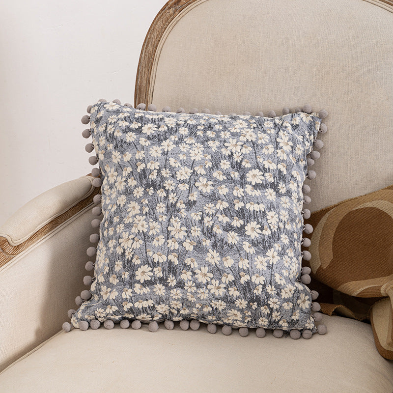 Dekoratives Wurfkissen mit floralen Pom-Poms
