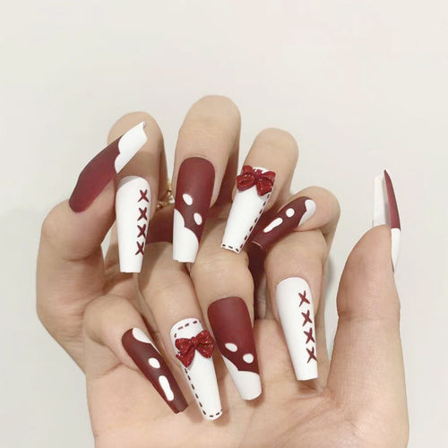 Kunstvolle Stiletto-Nägel mit Schleifen- und Zickzackdesign Karnz