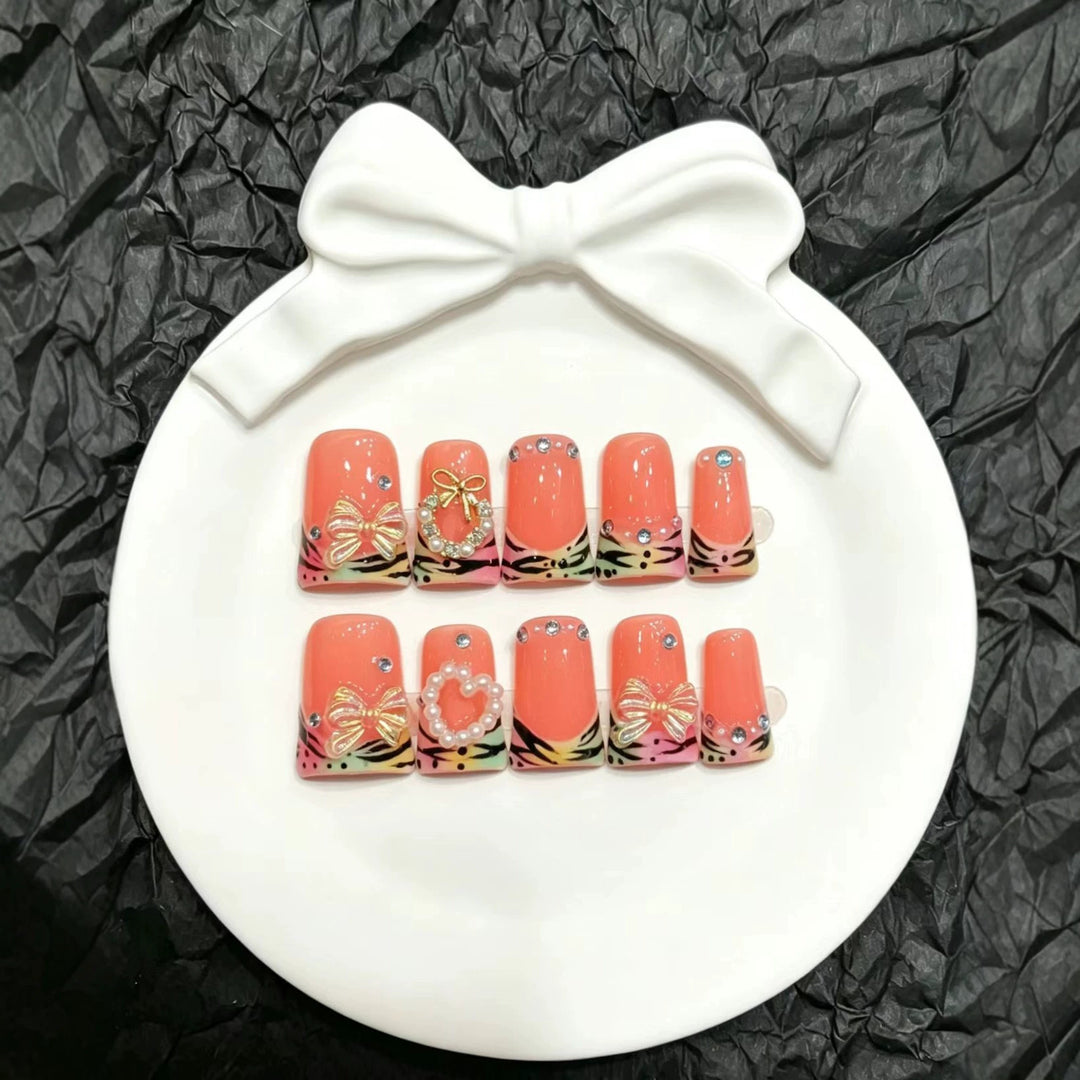 Dekoratives Press-On Nagelset mit eleganten Blumen- und Schleifenakzenten