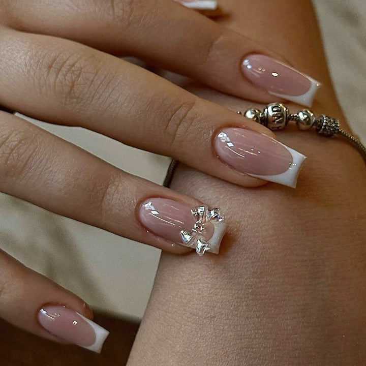 Kunstnagelset mit luxuriösen French-Tipps und eleganten Schmuckverzierungen Karnz