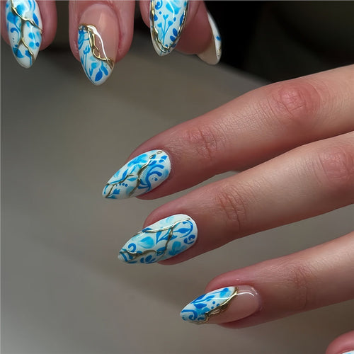 Künstlerisches florales Press-On-Nageldesign mit goldenen Akzenten Karnz