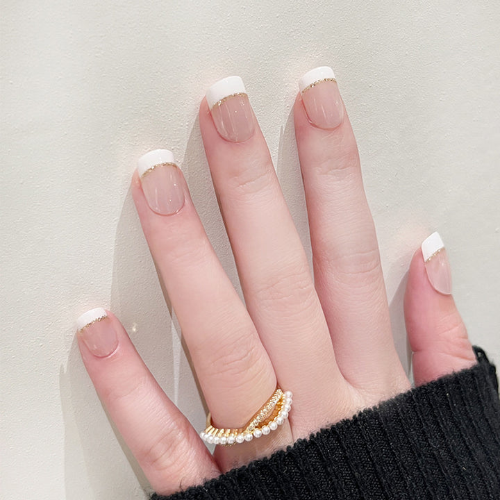 Kunstvolle Nagelverlängerungen mit elegantem French-Tip und Goldakzenten Karnz
