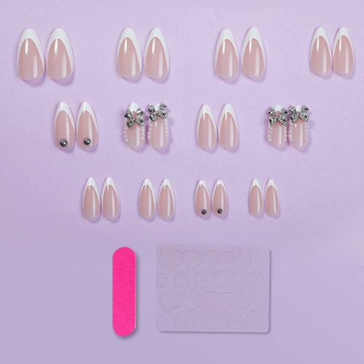 Kunstnagelset mit eleganten French-Spitzen und Dekorationsakzenten Karnz