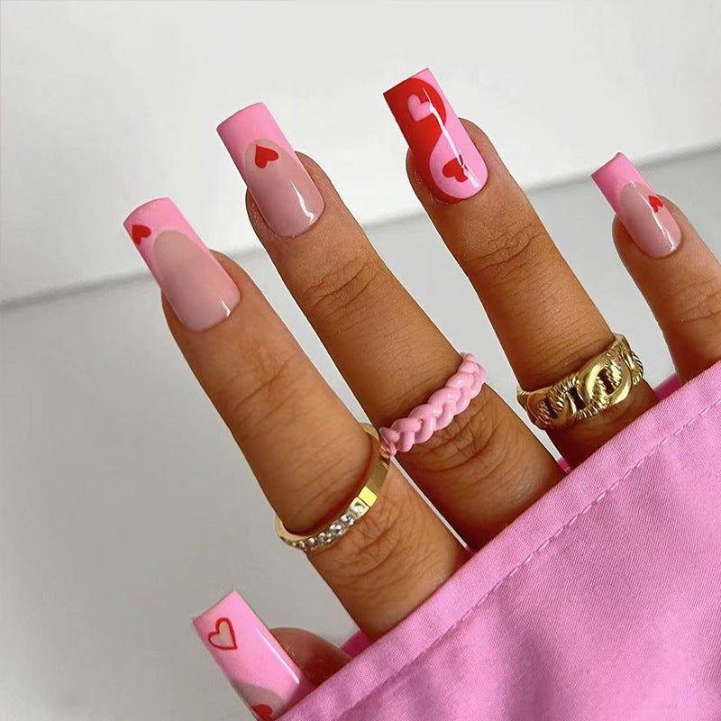 Künstliche Nagelkunst mit Herz-Design und Glitzerakzenten Karnz
