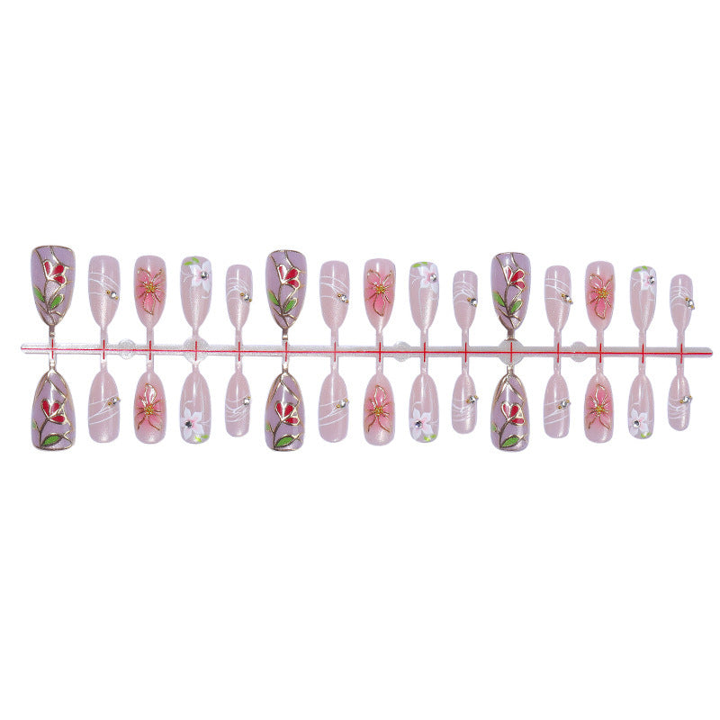 Kunstnagelset mit filigranen floralen Verzierungen und glänzenden Details Karnz