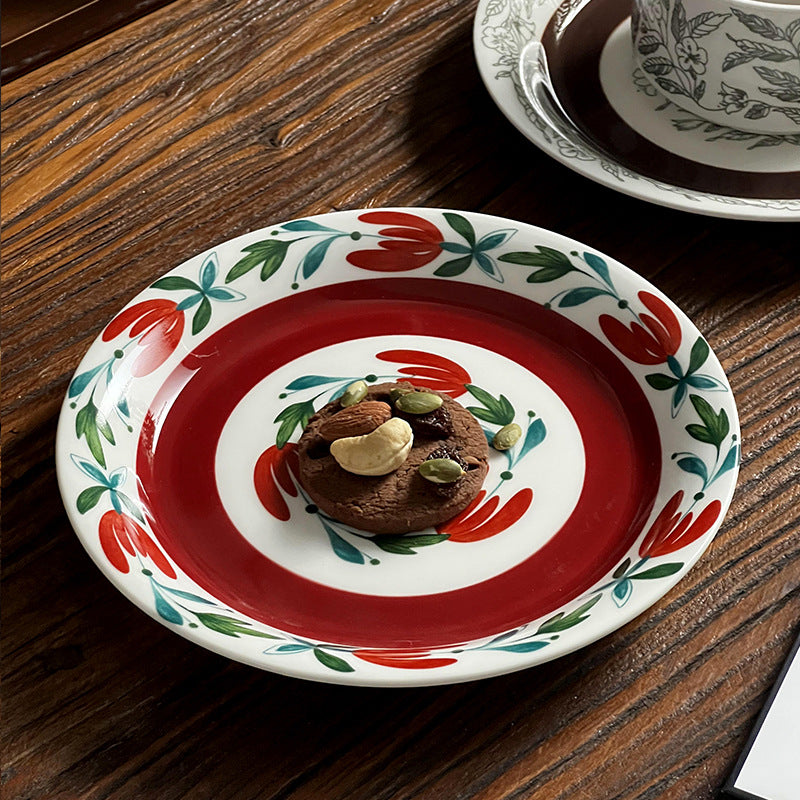 Tiefer Porzellanteller mit floraler Randornamentik und kontrastierendem Innenspiegel